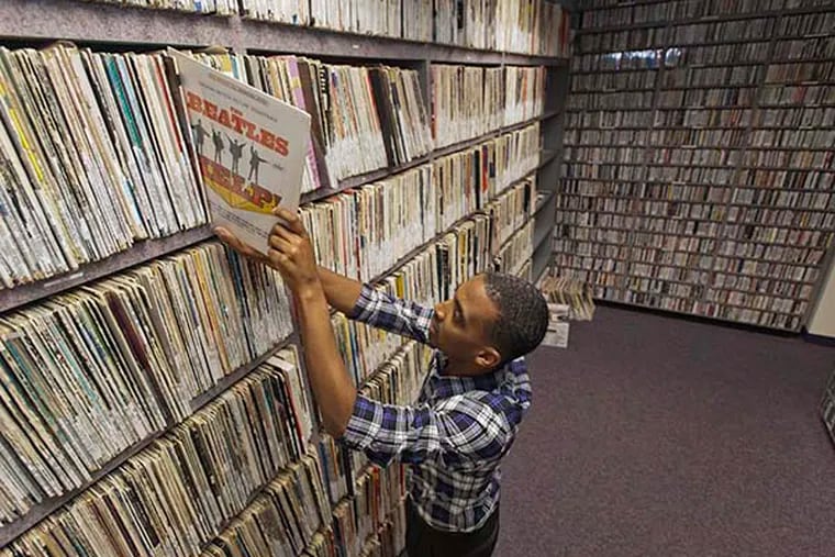 Derek Jones, station manager of Rowan University radio station WGLS, pulls a record from the music library of the station, which is celebrating 50 years on the air in Glassboro, N.J.  ( RON TARVER / Staff Photographer )