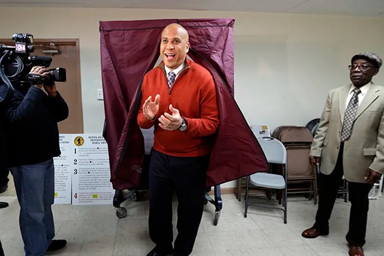 Sen. Cory Booker, D-N.J.,  applauds while exiting a voting booth after casting his vote in the 2014 general election, Tuesday, Nov. 4, 2014, in Newark, N.J.  Booker is going up against Republican challenger Jeff Bell. (AP Photo/Julio Cortez)