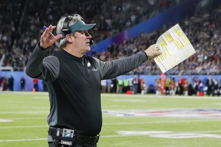 Eagles head coach Doug Pederson raises his arms after his defense stopped the New England Patriots in Super Bowl LII on Sunday, February 4, 2018 in Minneapolis. YONG KIM / Staff Photographer
