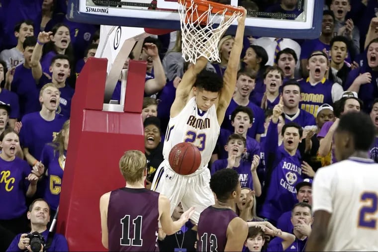 Roman Catholic guard Seth Lundy hangs on the rim after his dunk as his team beat St. Joseph’s Prep on Wednesday in the Catholic League semifinals.