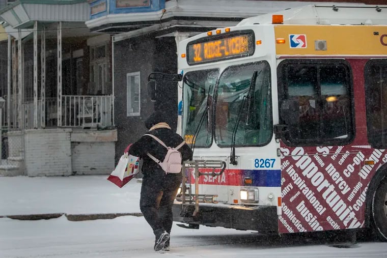 SEPTA, 32 bus waited for a rider hustling to bus during snow fall over Philadelphia and region on Thursday morning February 18, 2021. The bus is on 30th Street about to go up Henry Avenue.