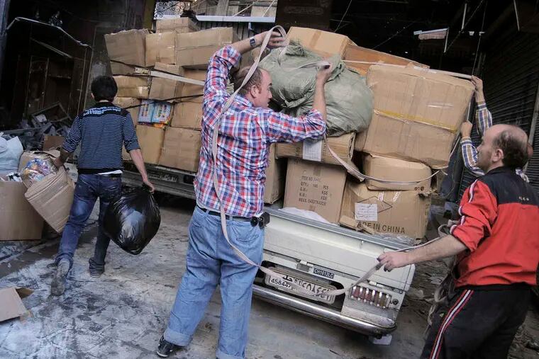 Merchants removing their wares from a marketplace in Aleppo, Syria. Thousands of business owners have moved abroad in the last year, to Lebanon, Turkey, and other places.