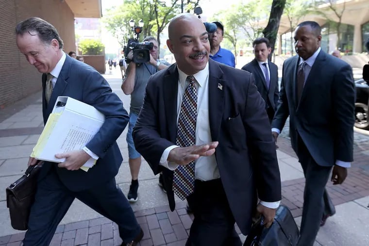 DA Seth Williams, center, waves on his way into the federal courthouse in Philadelphia, PA on June 22, 2017.