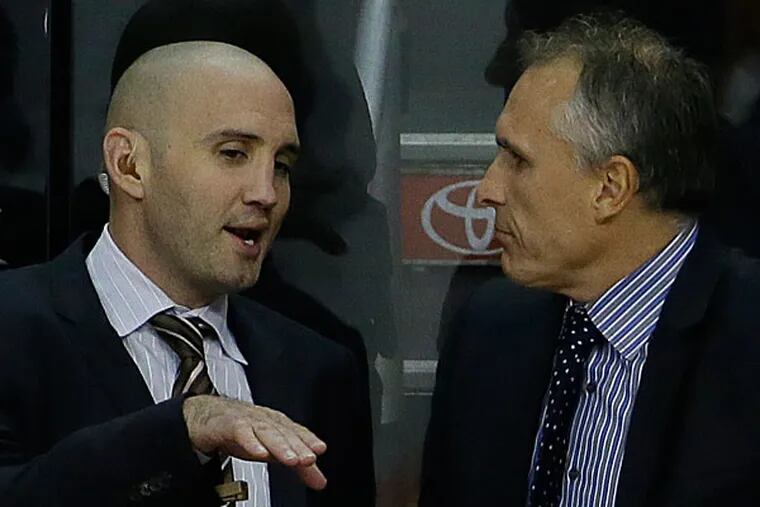 Flyers head coach Craig Berube talks with assistant coach Ian Laperriere. (Matt Slocum/AP)