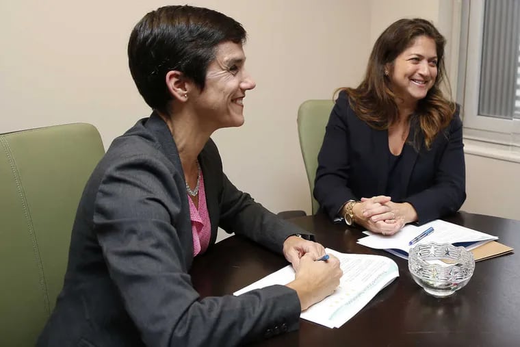 Commissioner of the Philadelphia Department of Human Services Cynthia Figueroa (right) with Deputy Commissioner, Performance Management and Accountability Liza Rodriguez smile while taking a break looking over reports.