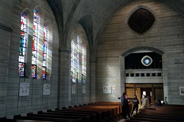 Students and faculty gather in the chapel with sunlight coming through the stained glass — which has been a focus of their study. Most of the people depicted in the stained glass are women.