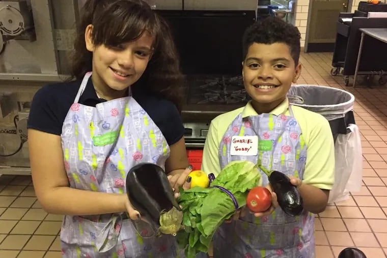 Bayard Taylor chefs Syliani Ortiz and Gabriel "Gobby" Rodriguez review the colorful rainbow of vegetables that they would prepare during week 4 of the fall 2018 My Daughter's Kitchen cooking program: purple eggplant, green lettuce, red tomato, yellow lemon, plus a honey crisp apple for a snack.