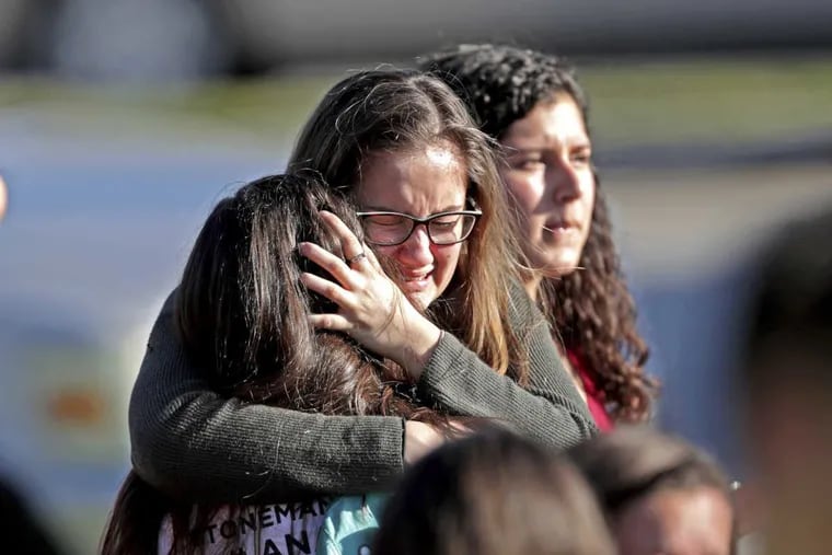 Students released from a lockdown embrace following a shooting at Marjory Stoneman Douglas High School in Parkland, Fla., Wednesday, Feb. 14, 2018.