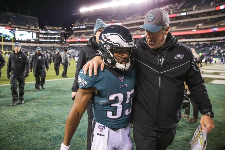 Coach Doug Pederson leaves the field with running back Boston Scott after the Eagles lost to the Seahawks.