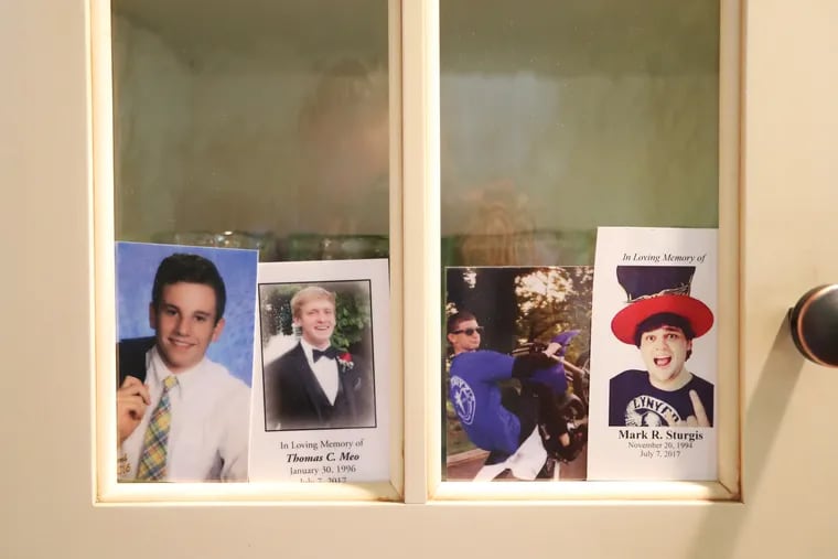 (L-R) Four photos of Jimi Patrick, Tom Meo, Dean Finocchiaro, and Mark Sturgis are placed in a kitchen cabinet window in the home of the Patricks, nearing the anniversary of the July 2017 murders of the four young men in Bucks County. DAVID SWANSON / Staff Photographer
