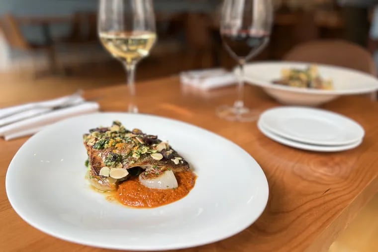 Dorade with braised escarole, cipolini onions, Romesco, toasted almond, and Taggiasca olives at Oltremare, 2121 Walnut St.