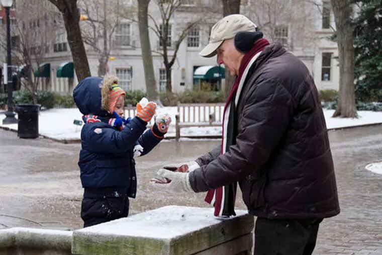 Bob Runyan (right) helps his grandson Jude Burkhart construct a miniature snowman in Rittenhouse Square on Monday, Jan. 26, 2015. (RACHEL WISNIEWSKI / Staff Photographer)