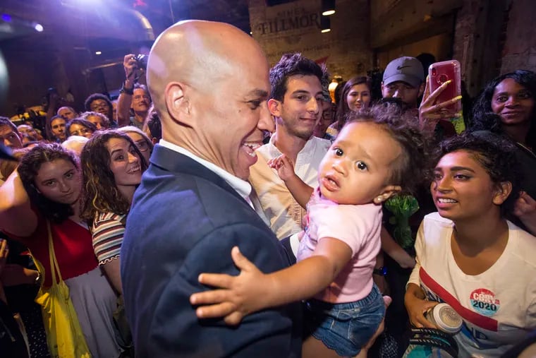 US Senator and Presidential candidate Cory Booker of New Jersey holds up a young child as he greets the crowd after speaking at a rally at The Fillmore in Philadelphia on Aug. 7, 2019.