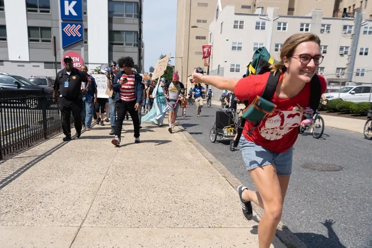 Becky Cave, a protest organizer. leads the charge with a "Naruto Run" as demonstrators march east on Cherry street outside the ICE field office in Philadelphia on Saturday.