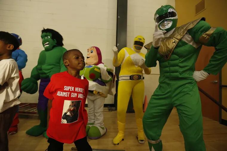 7-year-old Mahaj “Haji” Brown, a shooting victim, dances with a group of superheroes.