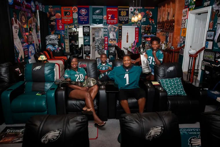 The Small family poses for a portrait inside Marty Small's fan cave in Atlantic City on Friday, Aug. 31, 2018. Small bought new memorabilia, including a Super Bowl champion banner, following the Eagles win in Feb.