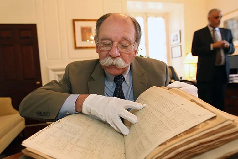 Randy Granger, art teacher and archivist assistant, looks through a book containing the Trustees' minutes from 1712 to 1769 at Haverford College.  ( MICHAEL BRYANT / Staff Photographer )