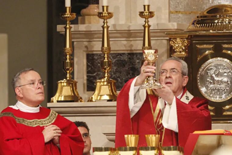 Archbishop Charles J. Chaput (left) assists Cardinal Justin Rigali in his first Mass offered at the Cathedral Basilica of SS. Peter and Paul. (Charles Fox / Staff Photographer)