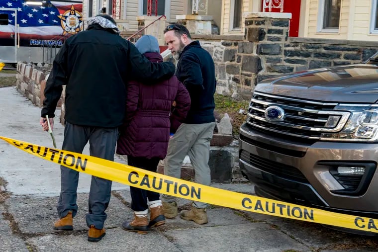 Police comfort Chin Le, the mother of Canh Le, outside of the home on Lewis Avenue in East Lansdowne Thursday.