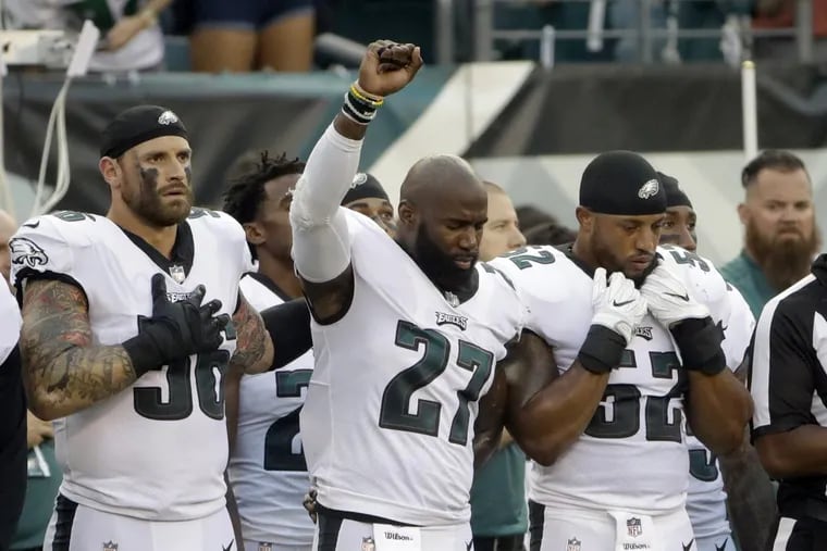 Malcolm Jenkins raised his fist during the national anthem and teammate Chris Long put his left arm around him before the team’s game against the Bills on Thursday.