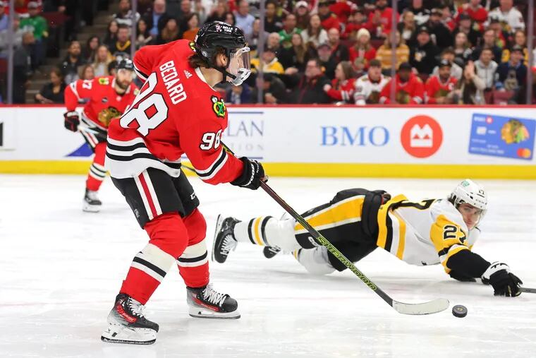 Connor Bedard #98 of the Chicago Blackhawks assist a goal by Philipp Kurashev #23 (not pictured) against the Pittsburgh Penguins during the second period at the United Center on February 15, 2024 in Chicago, Illinois.