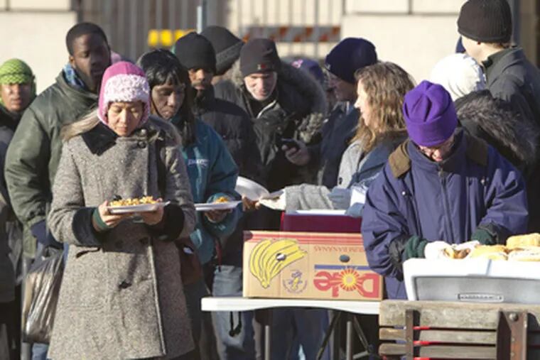 People line up for food in the plaza on Vine Street across from Family Court. (David M Warren / Staff Photographer)