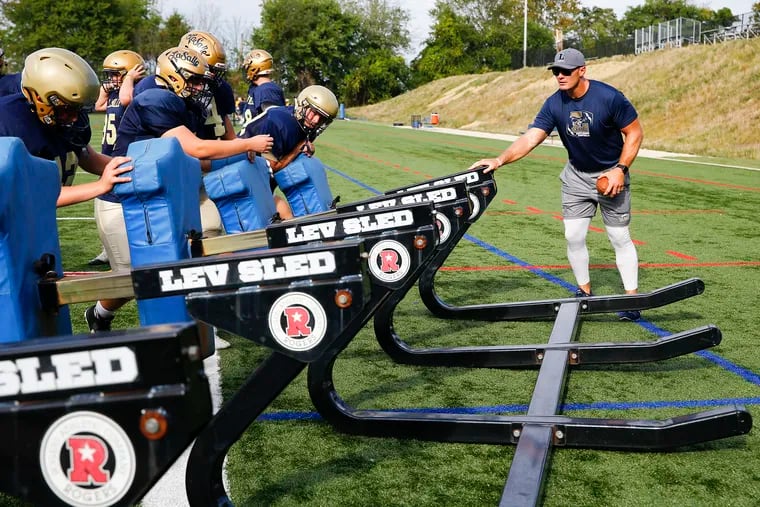 La Salle offensive line coach Chris Myers (right) works with his players during practice in September. He was an NFL star for the Houston Texans.