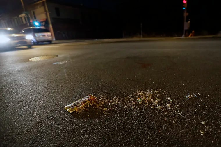 Blood and M&M’s left in the road after a teenage girl was shot and killed by random gunfire when she got off a bus at North 22nd Street and Sedgley Avenue in North Philadelphia.