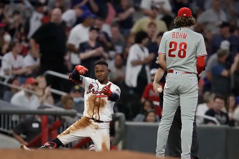 Braves second baseman Ozzie Albies celebrates beside the Phillies' Alec Bohm after hitting a triple in the fourth inning Saturday night in Atlanta.