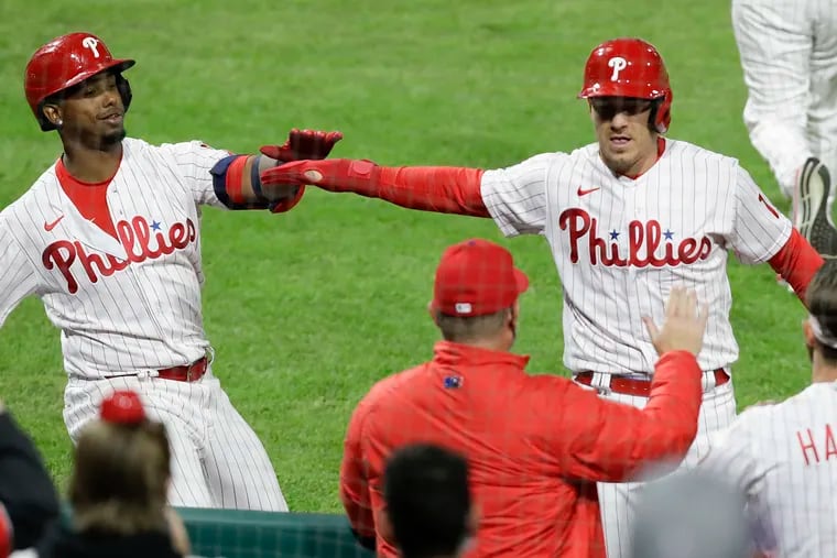 J.T. Realmuto celebrates his run scored with teammate Jean Segura during the Phillies' eighth-inning rally Monday night against the Mets.