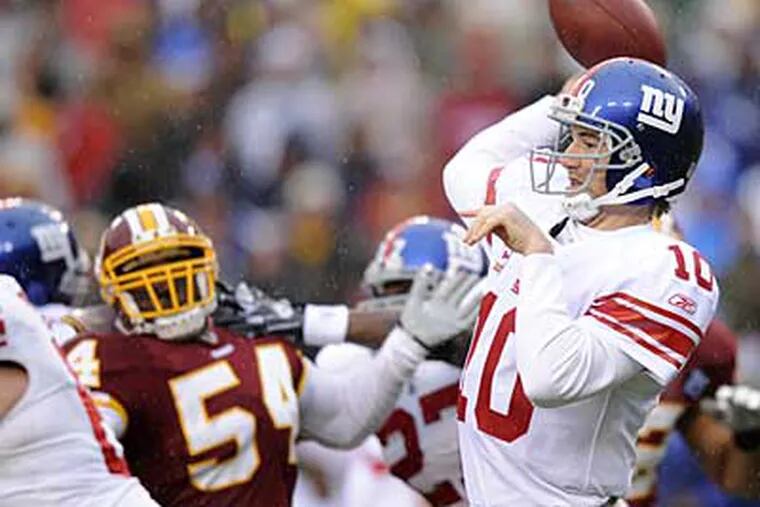 New York Giants quarterback Eli Manning (10) looks to pass against the Washington Redskins as Redskins linebacker H.B. Blades (54) during a Nov. 30 game. (AP)