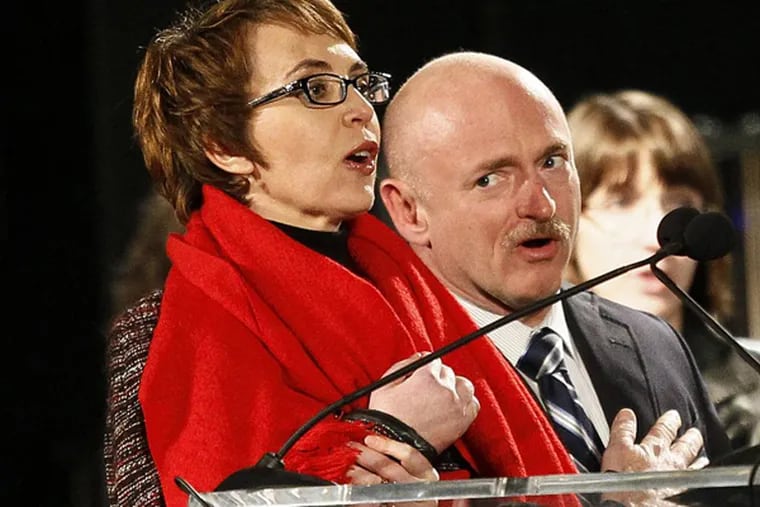 FILE - Rep. Gabrielle Giffords, left, leads the Pledge of Allegiance accompanied by her husband, former astronaut Mark Kelly, at the start of a one year memorial vigil for the victims and survivors of the shooting that wounded Giffords, 12 others and killed six in this Sunday, Jan. 8, 2012 file photo taken in Tucson, Ariz. The three-year anniversary of the shooting of Gabrielle Giffords will be marked Wednesday Jan. 8, 2013 with bell-ringing, flag-raising and other ceremonies, providing a moment of reflection for the former congresswoman. Giffords and Kelly plan to mark the anniversary privately with friends and other survivors of the attack. (AP Photo/Matt York, File)