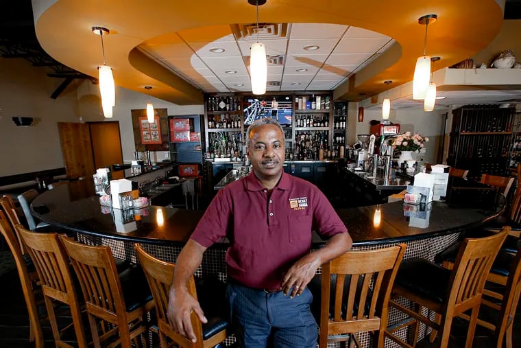 Kassahun Kebede, an immigrant from Ethiopia, poses for a photo at his restaurant, Yenat Guada Ethiopian Cuisine, Friday, August 9, 2019.