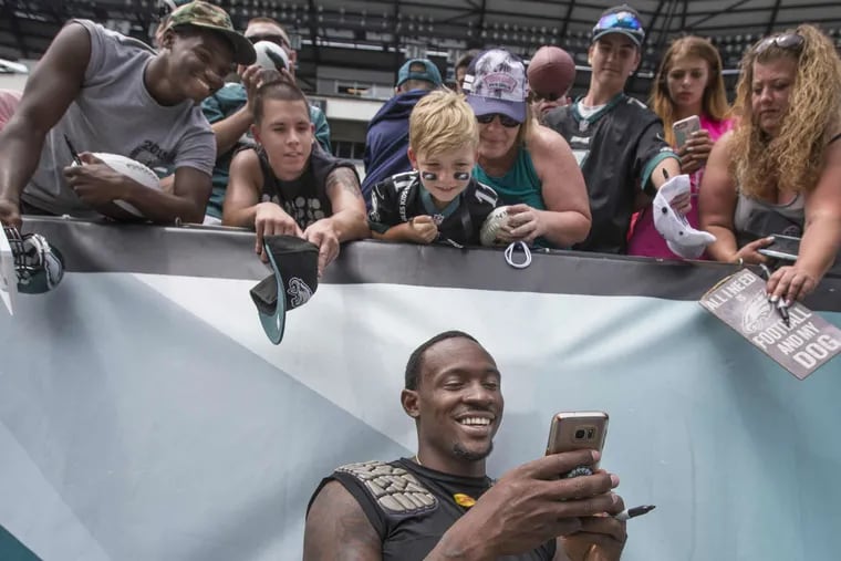 Eagle receiver Alshon Jeffery, center, smiles as he takes a selfie of himself for the little Eagles fan above him, after the open practice on Sunday August 6, 2017 at Lincoln Financial Field.