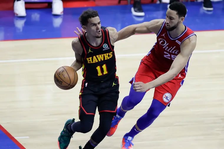 Atlanta Hawks guard Trae Young dribbles the basketball against Sixers guard Ben Simmons in Game 1 of the NBA Eastern Conference playoff semifinals on Sunday, June 6, 2021.