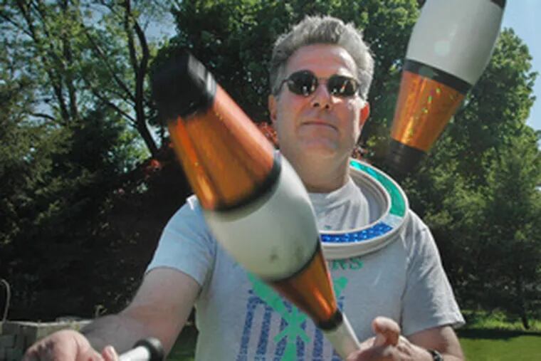 Jack McMichael, 54, juggles three pins in the back yard of Domenic Lopez. While juggling balls may be the first item attempted, those interested also turn to tossing pins, throwing yo-yos and speed-stacking cups.