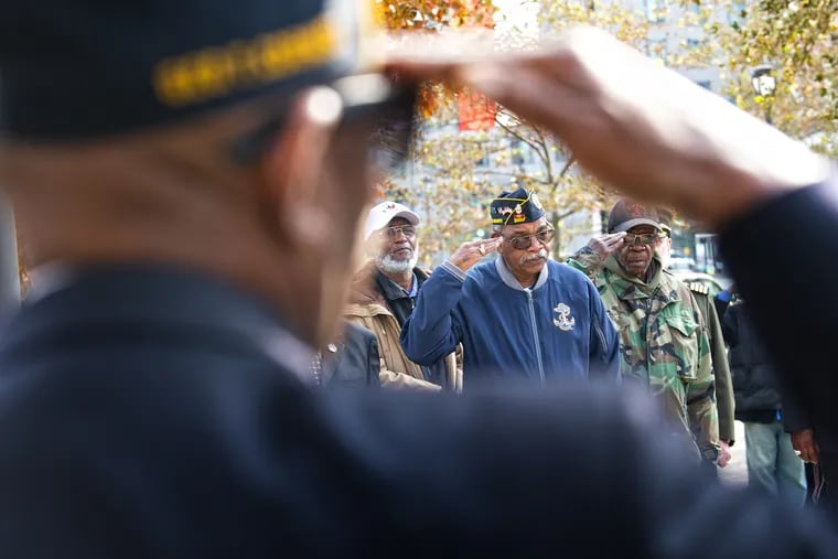 George Cross, III, a veteran, salutes the flag during a ceremony at the All Wars Memorial to Colored Soldiers and Sailors.