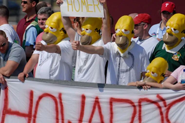 Fans calling themselves Howard's Homers wear special masks as they cheer Phillie phenom Ryan Howard at the ballclub's home opener against the Atlanta Braves yesterday.
