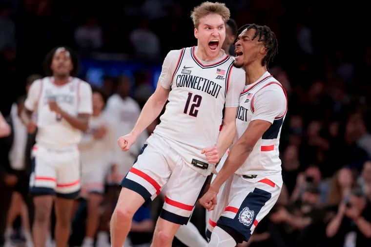 Cam Spencer, center, and Stephon Castle of UConn, celebrate after a 2nd half run against St.John's on Friday night. The Huskies won the Big East tournament semifinal game, 95-90.