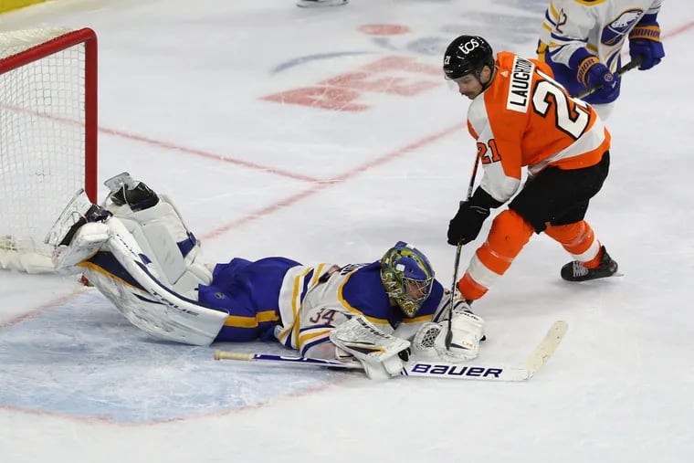 Scott Laughton, right, of the Flyers has his shot blocked by Jonas Johansson of the Sabres during overtime period at the Wells Fargo Center on March 9, 2021.