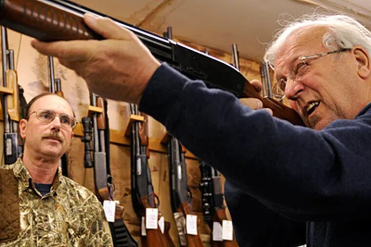 Ed Tarpy watches as Jerry Fraley, 69, of Blackwood, checks out a gun at Tarpy's shop in Deptford. Gun laws in New Jersey are among the toughest in the United States. (Tom Gralish / Staff Photographer)