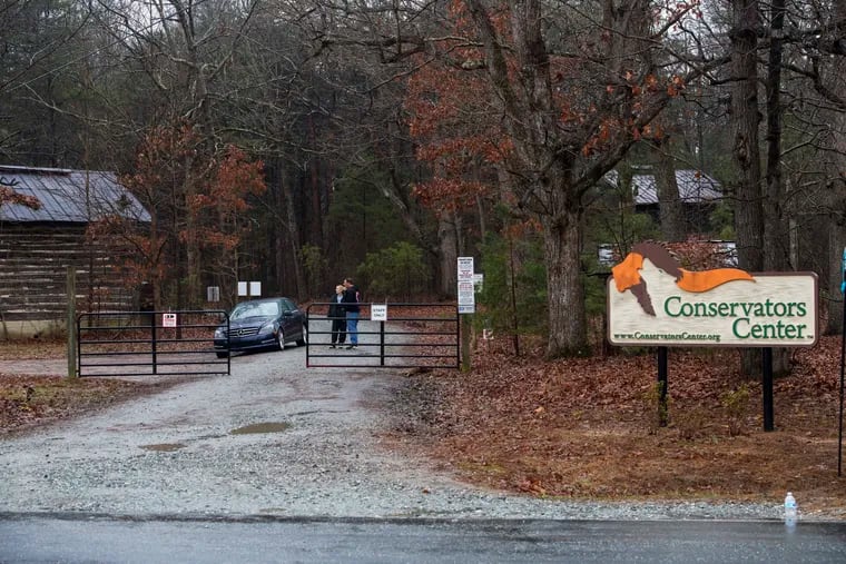 Conservators Center workers stand at the gate of the property in Burlington, N.C., Monday, Dec. 31, 2018. An intern was cleaning an animal enclosure at the North Carolina wildlife center when a lion escaped from a nearby pen and attacked her, killing the young woman and sending visitors out of the zoo, authorities said.