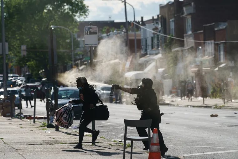 A police officer uses a spray on a person at 52nd and Chestnut streets in West Philadelphia on Sunday, May 31, 2020. On the second day of the George Floyd Protests.