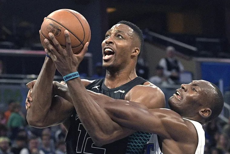 Charlotte center Dwight Howard (12), getting fouled by Orlando center Bismack Biyombo, and his Hornets teammates are 28-34.