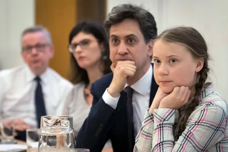 Environment Secretary Michael Gove, left, Former Labour leader Ed Miliband, second right, and Swedish climate activist Greta Thunberg, right, at the House of Commons in Westminster, London, to discuss the need for cross-party action to address the climate crisis, Tuesday, April 23, 2019. (Stefan Rousseau/PA via AP)