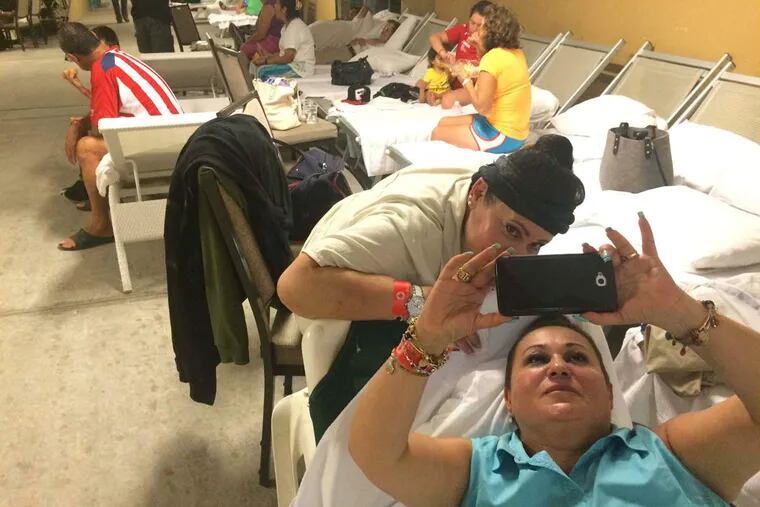 Sisters Patricia (left) and Maria Elena Lopez, from Mexico City, take a selfie in the evacuation shelter for the Grand Mayan Resort in Nuevo Vallarta, Mexico, before Hurricane Patricia,a category 5, makes landfall.