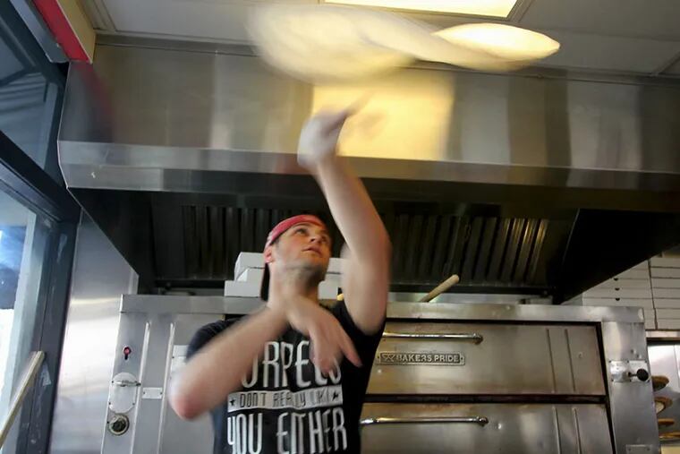 Charles Franzone III tosses a pie at his new Manayunk shop. ( Michael Klein / Philly.com )