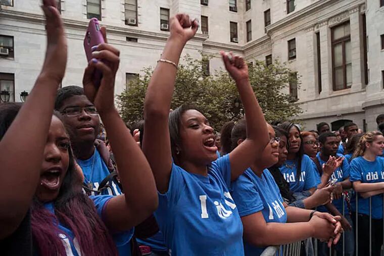 In June 2013, Shanera Porter (from left) from Lamberton High School and Dominique Brown Raslei from Philadelphia Academy Charter School cheer while Mayor Nutter talks about needing more funding for the Philadelphia School District. (Andrew Renneisen/Staff/File)