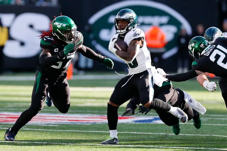 Miles Sanders runs with the football during the first quarter against the New York Jets as linebacker C.J. Mosley (left) moves in.