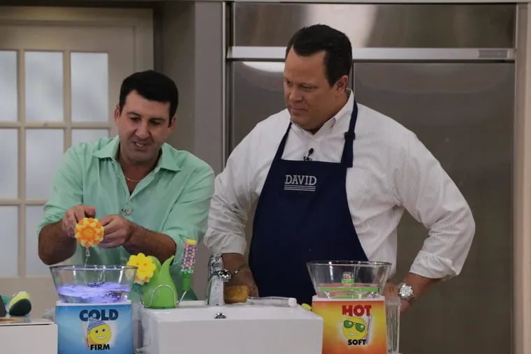 Aaron Krause, president and CEO of Scrub Daddy Inc., demonstrates his new Scrub Daisy product line to David Venable (right), host of QVC’s “In the Kitchen With David.”